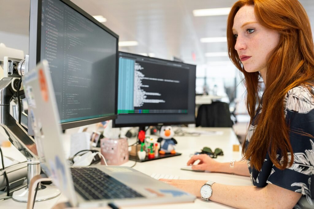 woman in green shirt sitting in front of computer woman in green shirt sitting in front of computer
